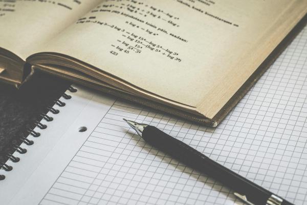Libro de ciencia con libreta y bolígrafo